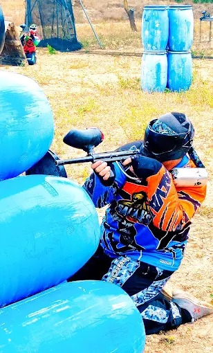 Amigos jugando al paintball deportivo con monitores especializados en campo de Sax Alicante